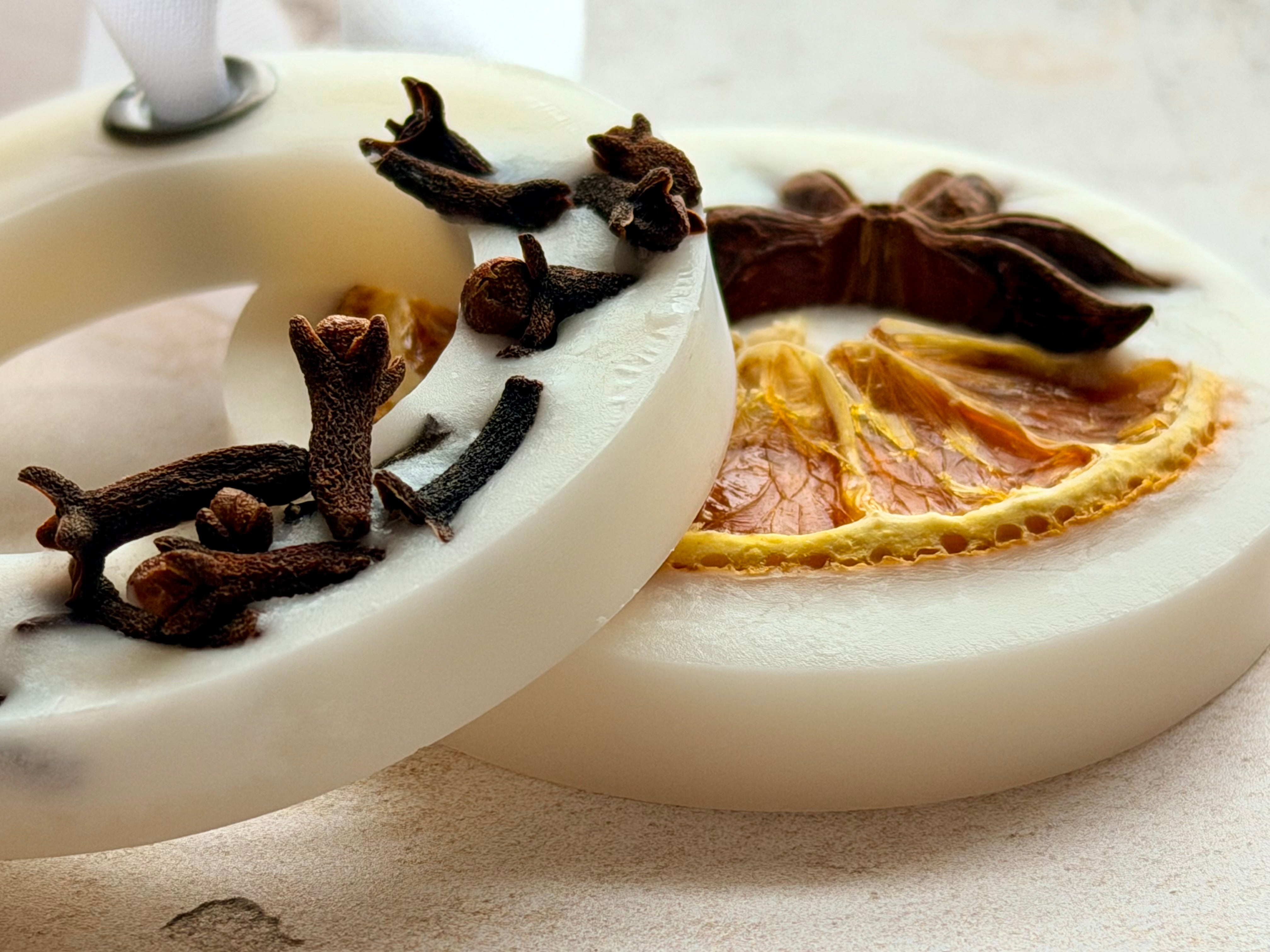 Hanging Wax Melt Decorations in cream, decorated with cloves, star anise and a dried citrus slice, with white ribbon.