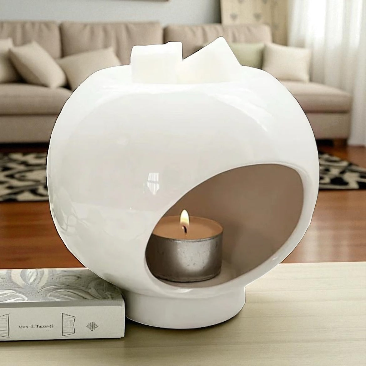 Quiet Orb Wax Burner — Gloss White Ceramic with a lit tealight in its oval opening and white wax pieces on top.